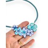 Collier créateur court fleuri monté sur cordon de caoutchouc, tons bleus