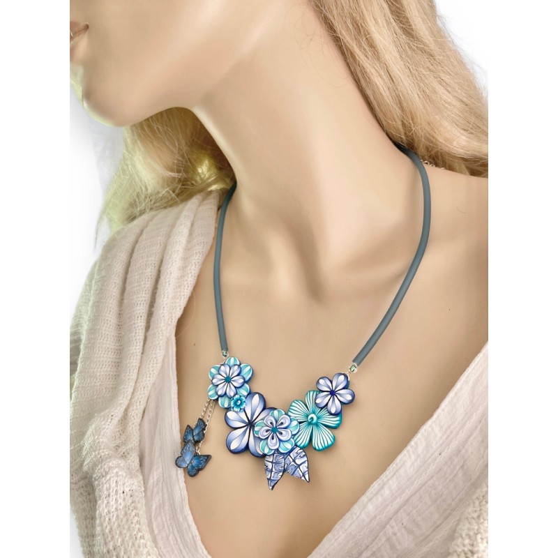 Collier créateur court fleuri monté sur cordon de caoutchouc, tons bleus